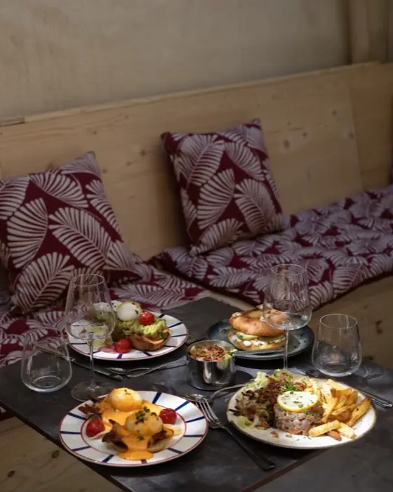 Banquette à coussins imprimés et table dressée pour le brunch.