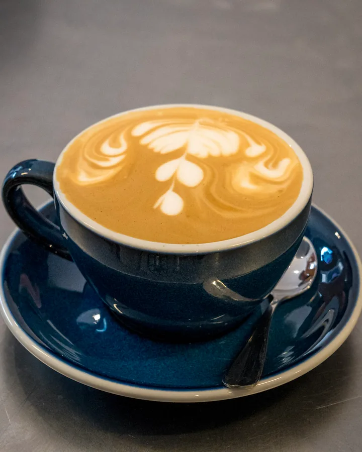 Tasse de café mousseux sur une soucoupe bleue