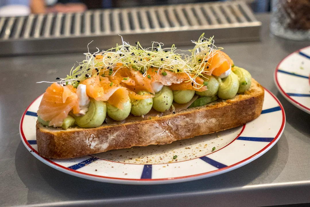 Tartine garnie sur une assiette rayée posée au comptoir