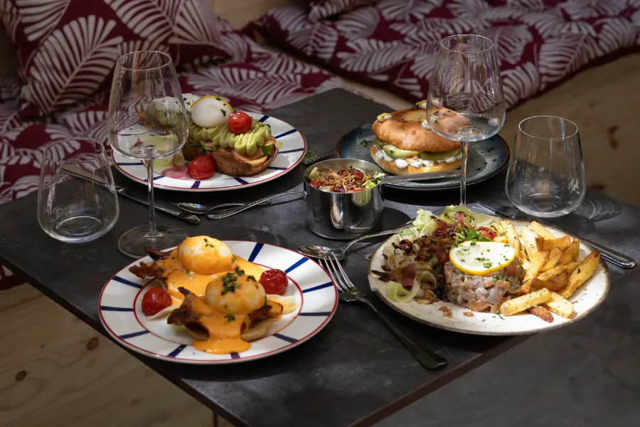 La table dressée, ses plats et ses verres de vin