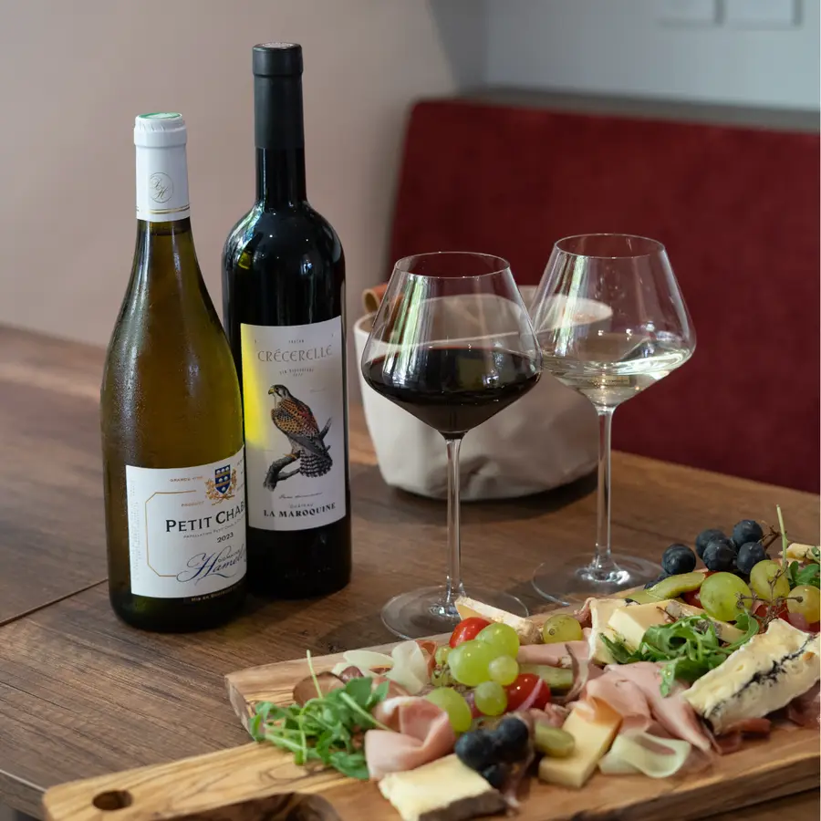 Bouteilles de vin, verres et planche de charcuterie au comptoir